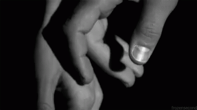 a black and white pograph of two hands with one hand holding the other's finger