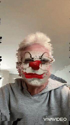 a man wearing white makeup and a clown like costume