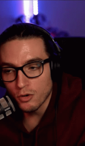 a man wearing glasses and headphones is talking on a radio