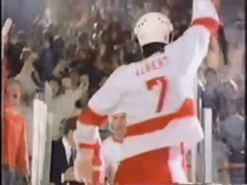 a hockey player waves to his teammates at a game