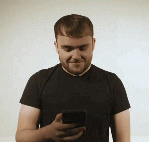 a man looking at his cell phone and smiling