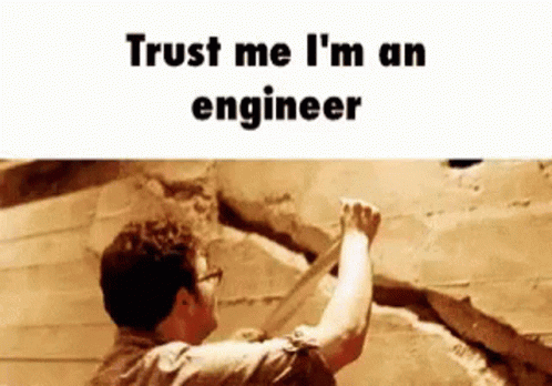 a man pointing at a wall with text that reads trust me i'm an engineer