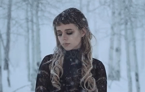there is a woman with long hair standing in the snow