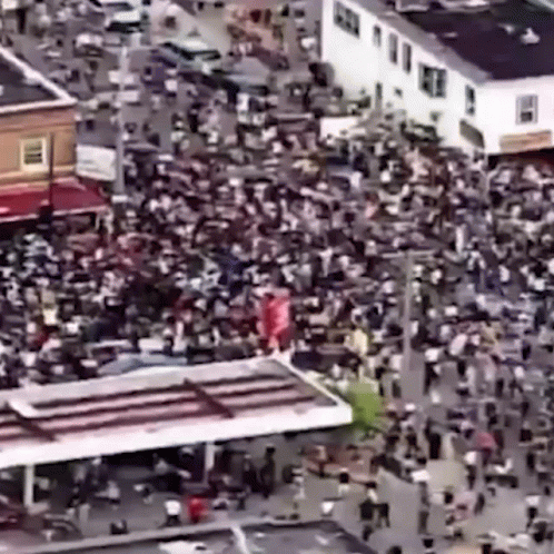 a huge crowd gathers around an intersection to watch the event