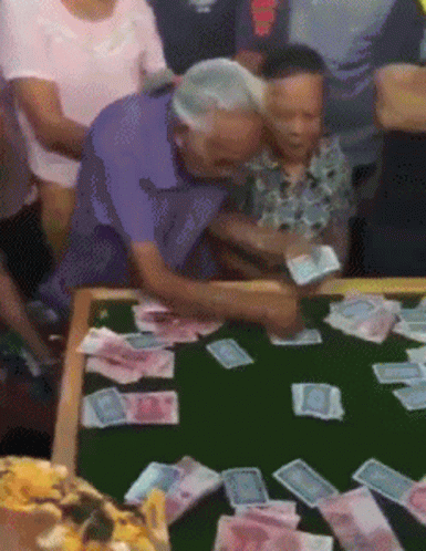 a group of people watching a table covered in stacks of money