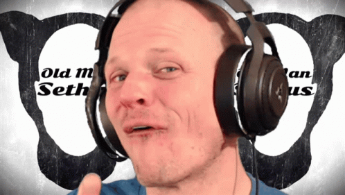 man with headphones making a face while showing thumbs up