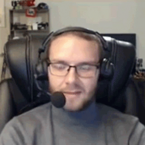 the man in glasses has a headset on and a microphone to his ear