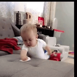 a toddler is trying to play on the couch