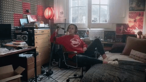 person sits on a chair while listening to soing in the corner