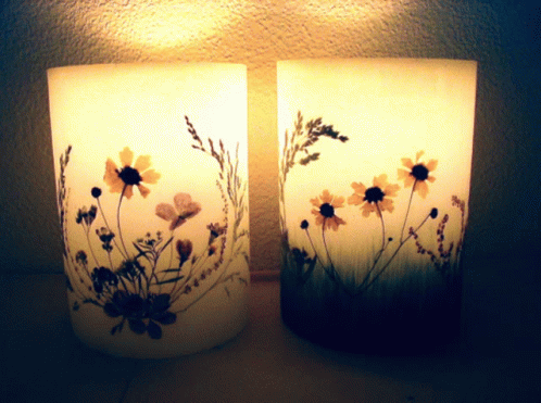 a close up s of two frosted vases with flowers on the sides