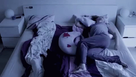 a person asleep on a bed with their head down