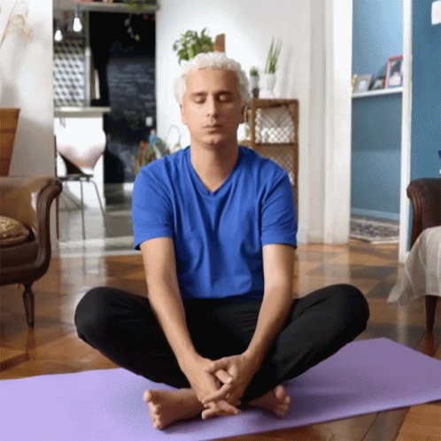 a man that is sitting on a yoga mat