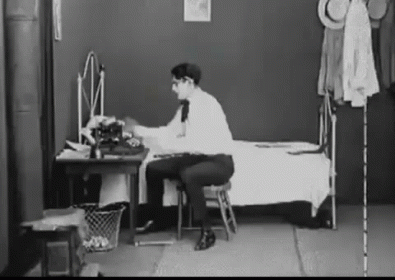 a young woman sitting in front of a desk with a computer