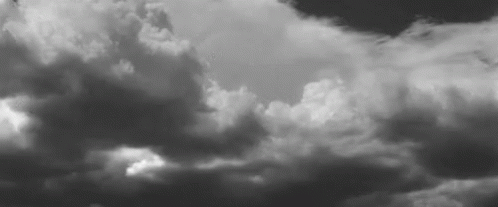 an airplane in the air as it flies through a cloudy sky
