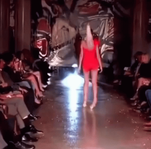 there is a woman walking on the runway