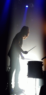 silhouette of person on drum kit in the dark