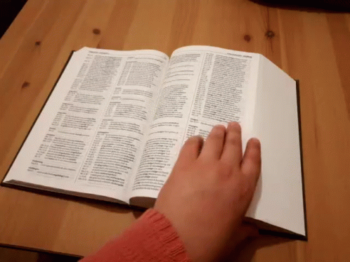 the person is reading the book and reaching for it