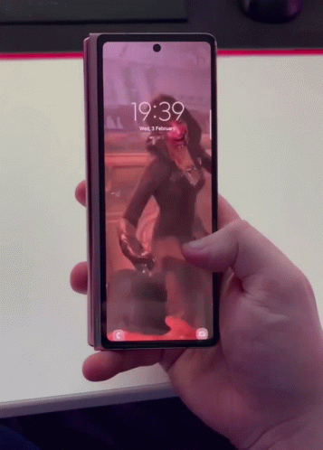 person holding up cell phone displaying po while taking picture