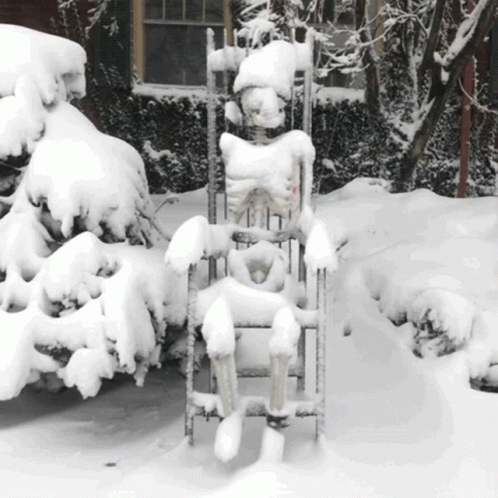 a snow covered lawn chair next to a pile of snow