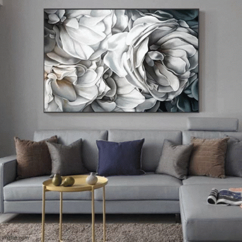 a painting of white and gray flowers above a sectional couch