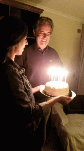 a man and a woman about to blow out candles on a cake