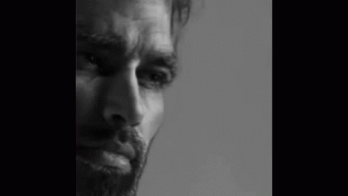 a black and white image of a bearded man