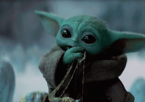 an action figure of the baby yoda is posed