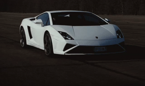this white supercar is driving in the dark