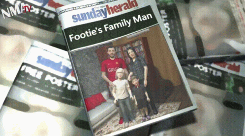 a person holding a news paper with the cover of footie's family man