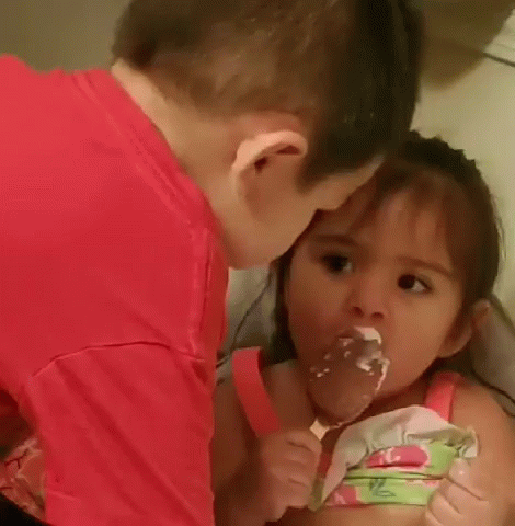a boy and a girl are eating cake together