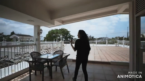woman looking at patio from balcony of house