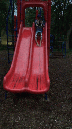 child on blue slide in playground setting