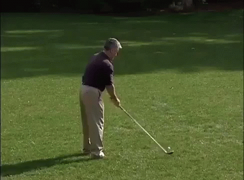 a man in black shirt playing golf on the grass