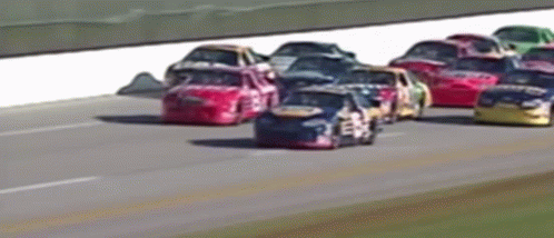 four small cars driving down a race track