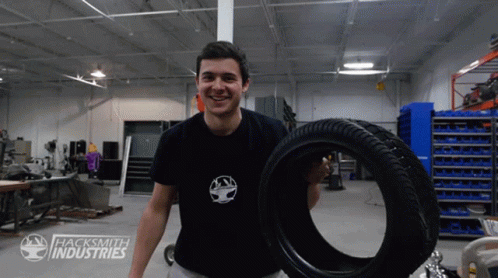 a man that is holding a large tire
