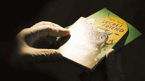 a person holding up a book with an owl on it