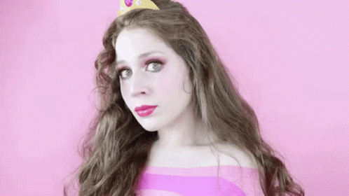a woman with long hair wearing a pink top