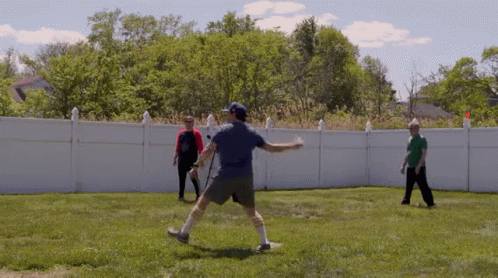 a man throwing a frisbee while walking across a grass covered yard