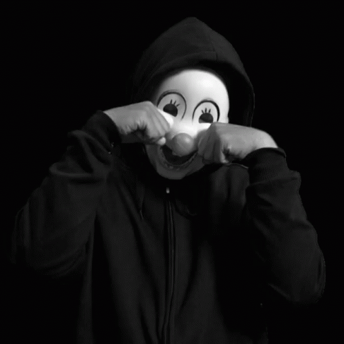a person is posing with a mask on and hand resting his face on his mouth