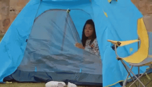 a woman is camping with her dog in the tent