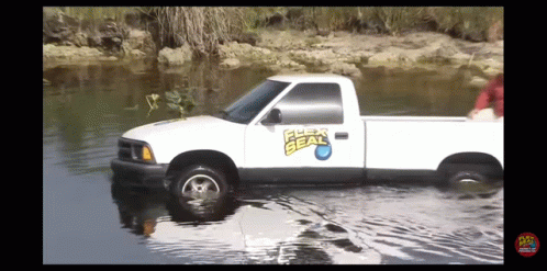 a white truck is parked in shallow water