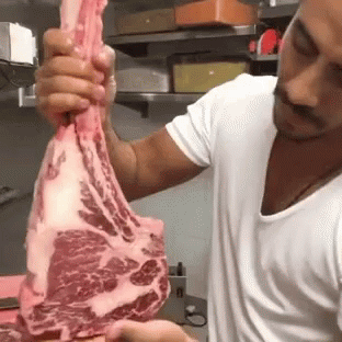 a man is holding up a piece of meat
