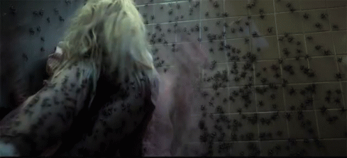 a person walking in a shower surrounded by flecky bugs