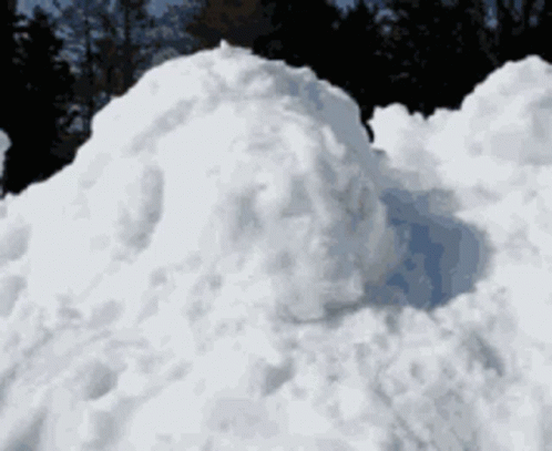 a snowboarder on skis going through a huge pile of snow