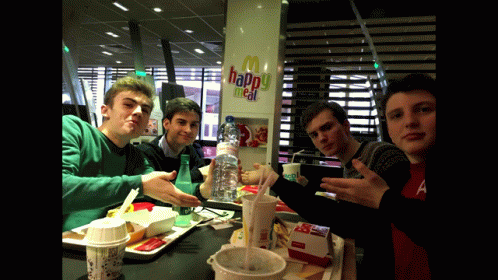 a group of men posing at a table with plastic cups and plates