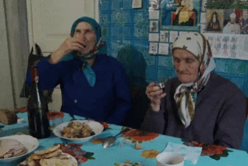 two women dressed in headscarves and sitting at a table