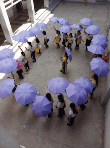 group of people standing around holding umbrellas and one woman standing behind them