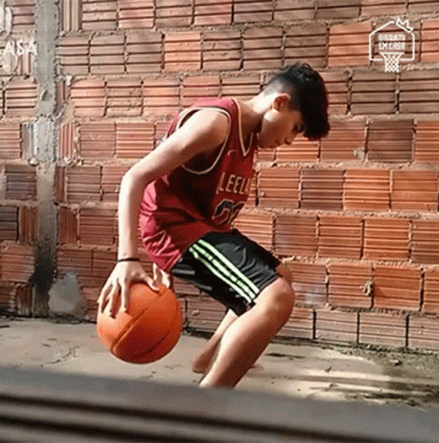 a basketball player in an empty room, with a ball in his hand