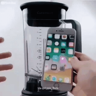 someone holds their phone in a blender with a lid
