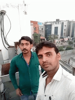 a couple of men posing for a picture on a balcony